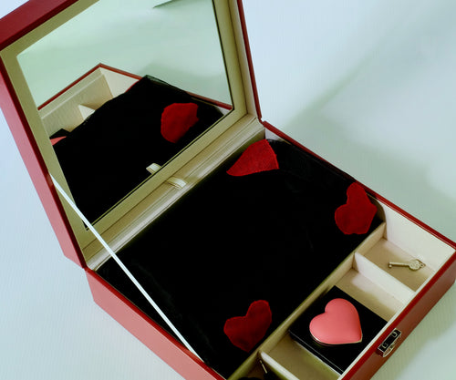 Scatola rossa con baby-doll nero e mini vibratore a forma di cuore.